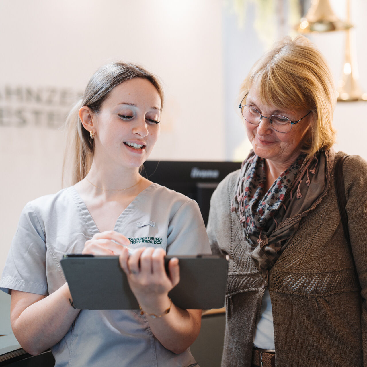 ZFA erklärt Patientin etwas am iPad