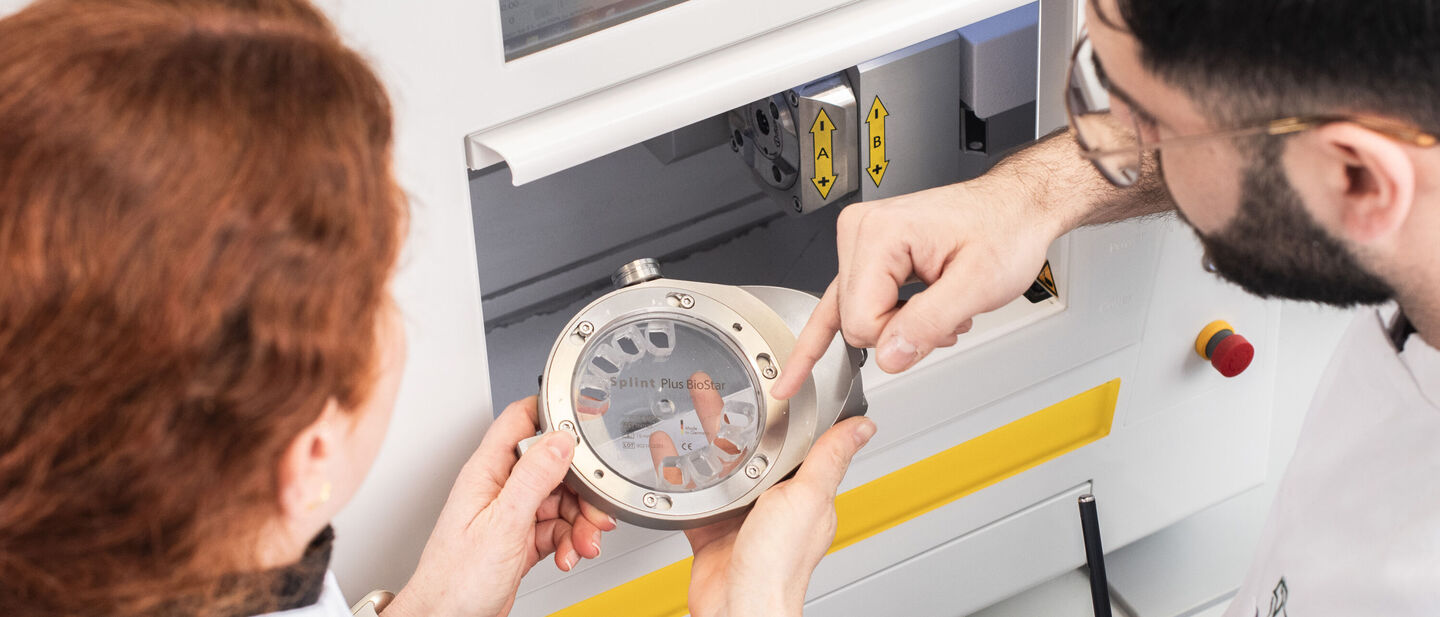 Zahntechniker stehen vor Fräse