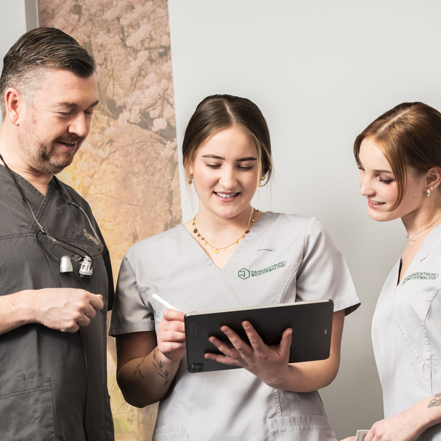 Zahnarzt mit Assistentinnen im Gespräch