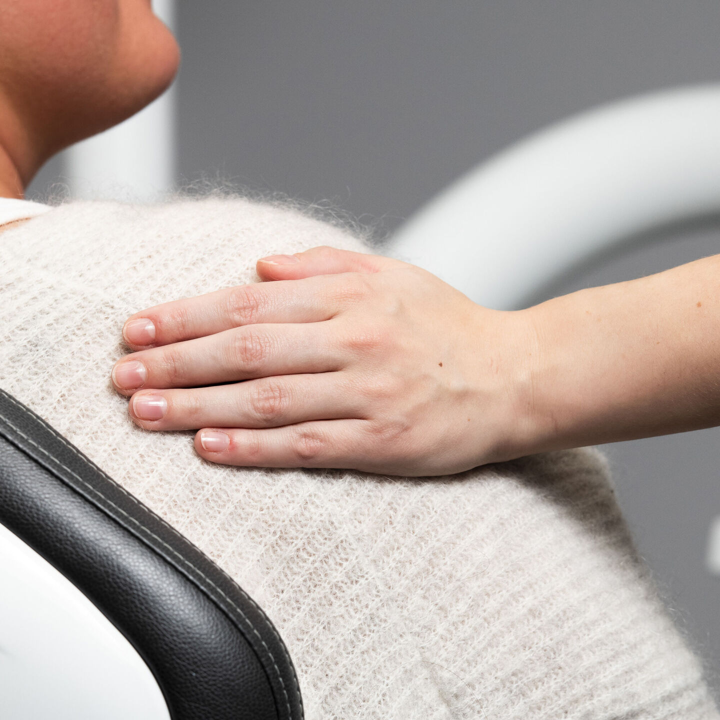 Beruhigende Hand auf der Schulter einer Patientin